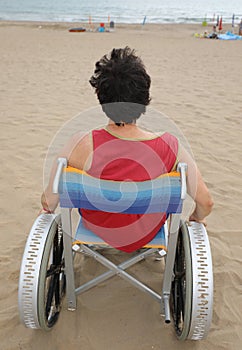 Young man on the wheelchair by the sea