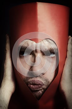 Young man with whimsical grimace in heart shape