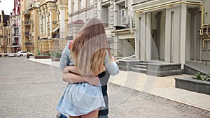 Young man whirling girl holding her waist tightly