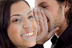 Young man whispering to woman