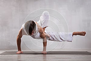 Young man in white clothes practicing yoga