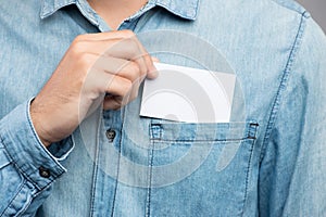 Young man who takes out blank business card from the pocket of h