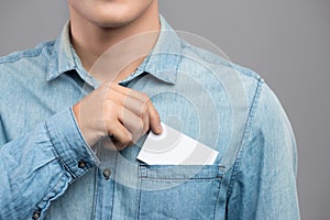 Young man who takes out blank business card from the pocket of h