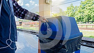 A young man who throws bottles into trash in a train station in Chiang Mai,