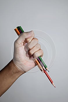 Young man wielding some sharpened pencil crayons