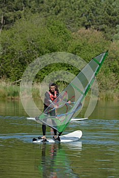 young man windsurfing on lake photo