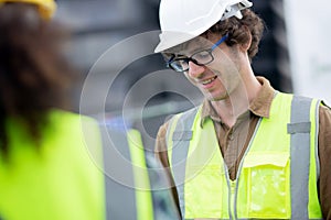 Young man and woman is architect planning and inspector project and looking digital tablet at construction site.