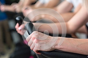 Young man and woman biking in the gym, exercising legs doing cardio workout cycling bikes