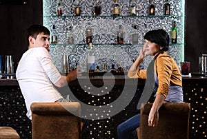 Young man and woman chatting at the bar