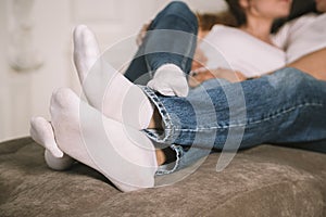 Young man and woman, couple in love lying on bed embracing legs in jeans, casual style, happy together