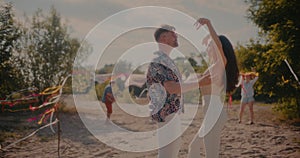 Young man and woman dancing bachata intimately at beach