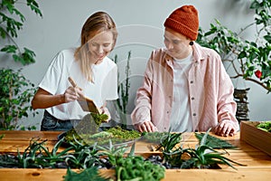 Young man and woman florist working at creative workshop