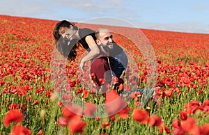 Young man and woman having date in the field of poppies