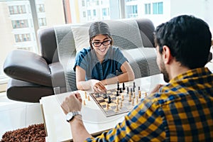 Young Man And Woman Having Fun And Playing Chess