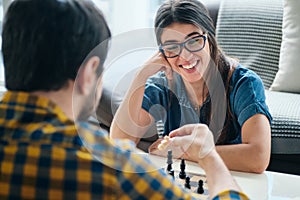 Young Man And Woman Having Fun And Playing Chess