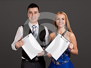 Young man and woman holding clip boards