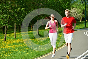 Young man and woman jogging outdoors