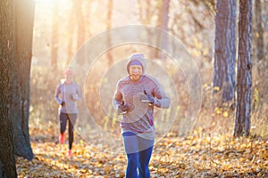 Young man and woman jogging on park trail