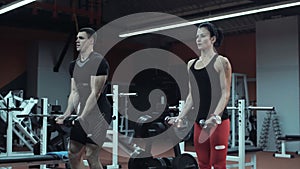 Young man and woman lifting weights in a gym