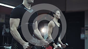 Young man and woman lifting weights in a gym