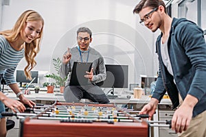 young man and woman playing in table soccer