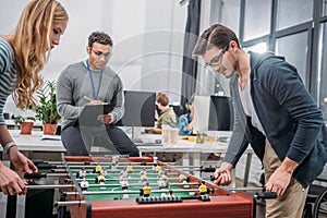 young man and woman playing in table soccer