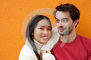 Young man and woman posing against orange background