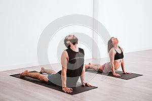 young man and woman practicing yoga sport at the gym. Healthy lifestyle