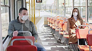 Young man and woman with protective mask traveling in the public transport by bus