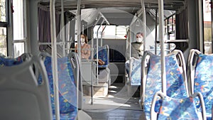 Young man and woman with protective mask traveling in the public transport by bus