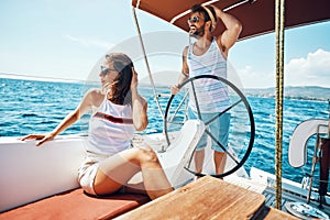 Young man and woman on a sailing boat -Romantic vacation and luxury travel