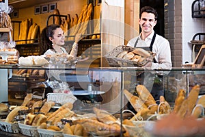 Young man and woman selling pastry and loaves