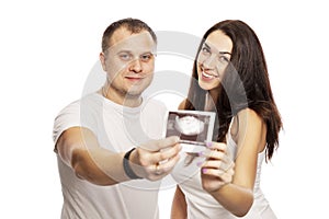 Young man and woman show the result of ultrasound. Early gestational age. Love and happiness waiting photo