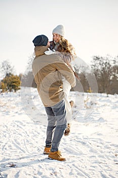 Young man and woman spending time together at winter day and hugging