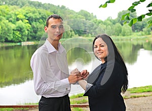 Young man and woman standing on the shore of the lake .