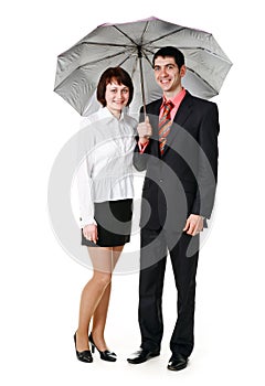 Young man and woman standing under an umbrella.