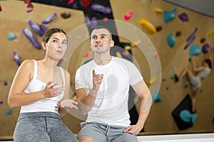 Young man and woman talking near climbing wall