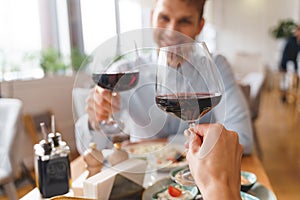 Young man and woman toasting with wine in restaurant