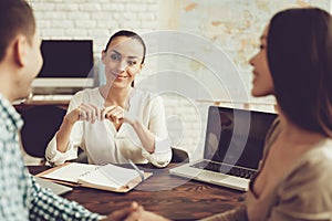 Young Man and Woman in Travel Agency with Manager.