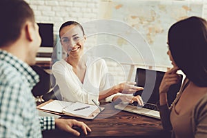 Young Man and Woman in Travel Agency with Manager.