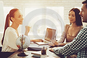 Young Man and Woman in Travel Agency with Manager.