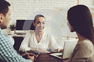 Young Man and Woman in Travel Agency with Manager.