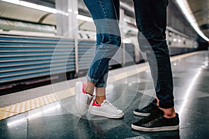 Young man and woman use underground. Couple in subway. Cut view of man and woman stand in front of each other. Fast