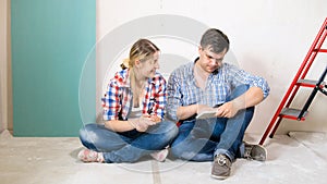 Young man and woman using digital tablet in house under renovation