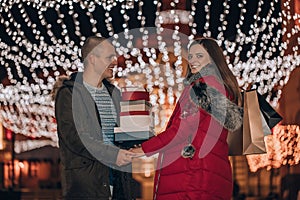 Young man and woman are walking and buying presents for their darlings and each other