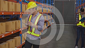 Young man and woman worker check stock and inspection with document on clipboard in the warehouse.