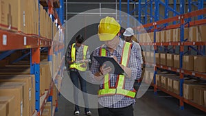 Young man and woman worker check stock and inspection with document on clipboard in the warehouse.