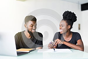 Young african man and woman working on laptop in business office