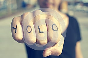 Young man with the word yolo, for you only live once, tattooed i