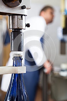 worker corking sparkling wine